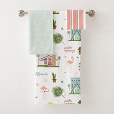 two towels hanging on a towel rack with palm trees and beach scenes printed on them