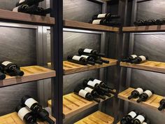 a wine cellar filled with lots of bottles of wine on wooden shelves next to each other