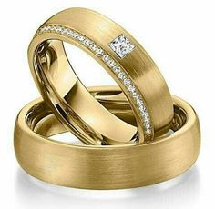 two gold wedding rings with diamonds on them