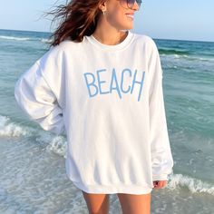 Stay cozy and stylish on breezy beach days with this comfortable beach sweatshirt. This sweatshirt is perfect for throwing on after a swim or for a casual evening walk on the beach. The relaxed fit makes it easy to layer over your favorite tank top or bikini, while the stylish beach-inspired design adds a touch of seaside charm to your look. Whether you're lounging on the sand or strolling along the boardwalk, this sweatshirt is the perfect addition to your wardrobe.  Gildan 18000 Crewneck unise Beach Pullover, Aesthetic Sweaters, Beach Sweatshirt, Summer Sweatshirt, Ocean Aesthetic, Summer Vacation Outfits, Evening Walk, Vacation Outfit, Casual Evening