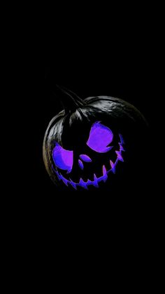 a lit up jack o lantern in the dark with blue light on it's face