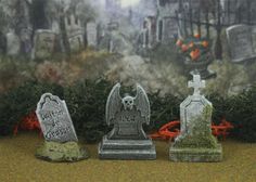 three tombstones sitting next to each other in front of a cemetery