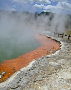 a man standing next to a pool of water with steam rising from the ground in front of him