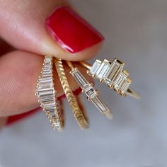 a woman's hand holding three different sized rings