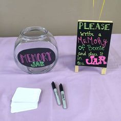 there is a glass jar with writing on it and two markers in front of it