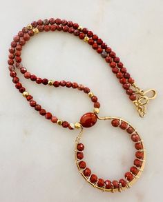 This statement necklace is on-trend and can serve as a layering necklace or hold its own by itself. Beautiful Red Jasper stones are highlighted by non-tarnish gold plated pewter faceted beads and a decorative non-tarnish gold plated pewter hook and eye clasp. Natural Gemstone Necklace. Red Jasper beads are 4mm round faceted round. Red Jasper is associated with grounding, stability, vitality, protection, emotional stability, passion, and spiritual alignment. Throughout history, turquoise has been Artisan Wire Wrapped Necklaces With Round Beads, Unique Wire Wrapped Beaded Necklaces With Round Beads, Unique Wire Wrapped Round Beaded Necklaces, Artisan Wire Wrapped Necklace For Jewelry Making, Beaded Jasper Round Beads Jewelry, Beaded Jasper Jewelry, Beaded Jasper Jewelry With Round Beads, Handmade Jasper Round Beads Necklaces, Gift Jasper Beaded Necklaces