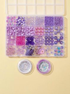 two plastic trays filled with lots of different beads and buttons on top of a table