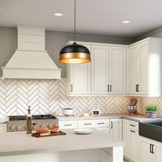 a kitchen with white cabinets and an island in front of the sink is lit by a black pendant light