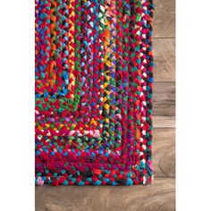 a multicolored rug on the floor with wooden floors and wood planks in the background