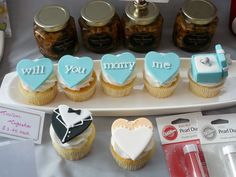 cupcakes and cookies are arranged on a platter with the words, will you marry me?