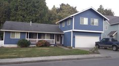 a blue house with a truck parked in front