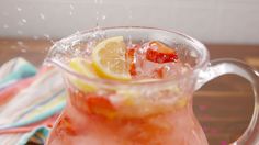 a pitcher filled with ice and lemons on top of a table