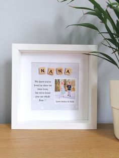 a wooden block with the word nanna spelled in it next to a potted plant