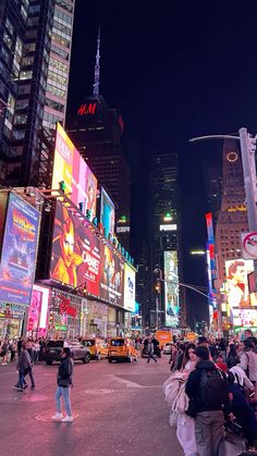 a busy city street filled with lots of tall buildings and people walking on the sidewalk