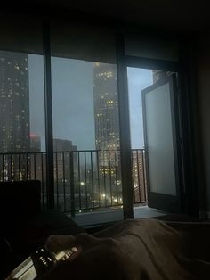 a bedroom with a view of the city at night