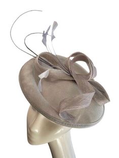 A stunning silver grey coloured sinamay flower fascinator comprised of a sinamay base, loops of sinamay in the same gorgeous shade of silver colour and hand shaped feathers finished with a double quill. This fascinator sits securely on your head with a satin covered headband in a coordinating shade. A stunning addition to any outfit! Fascinator measures approx 26cm Headband measures 1cm wide Please note as our fascinators are hand dyed to order if you feel this colour may not be quite right please request to see a colour chart. If you would like the fascinator created in an alternative dye colour which we don't currently stock there will be a charge of £30 to cover the cost of the dye and the labour.  Our timeless pieces are perfect for any special occasion from Weddings to The Kentucky De Silver Fascinator For Kentucky Derby Races, Silver Fitted Fascinator For Evening, Silver Headpiece For Party At Royal Ascot, Silver Headpieces For Party At Royal Ascot, Silver Fascinator For Kentucky Derby Party, Silver Adjustable Headpiece For Kentucky Derby, Fitted Silver Mini Hat For Formal Occasions, Silver Evening Fascinator For Kentucky Derby, Silver Fascinator For Evening At Kentucky Derby