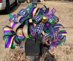 a purple and green wreath on top of a mailbox