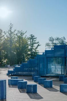 many blue crates are stacked on top of each other in the middle of a park