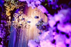 purple flowers and chandeliers in front of a stage backdrop with the word events written on it