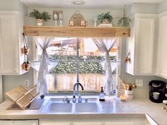 a kitchen with white cabinets and an open window