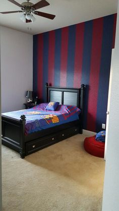 a bedroom with red, blue and black striped walls