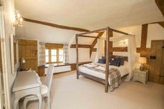 a bedroom with a four poster bed and white furniture