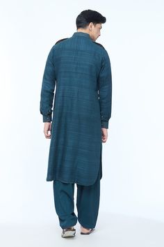 Teal blue full sleeves Pathani style kurta crafted in handloom silk with all over textured lines detailing and stitchlines on the collar, cuffs, placket and pocket flaps. Paired with a salwar. - Aza Fashions Blue Long Sleeve Kurta With Naqshi, Blue Sherwani With Naqshi Long Sleeve, Traditional Long Sleeve Handloom Sherwani, Blue Long Sleeve Sherwani With Naqshi Detailing, Blue Long Sleeve Kurta For Eid, Long Sleeve Indigo Kurta For Festive Occasions, Blue Long Sleeve Sherwani With Dabka Details, Blue Cotton Silk Long Sleeve Sherwani, Festive Long Sleeve Indigo Kurta