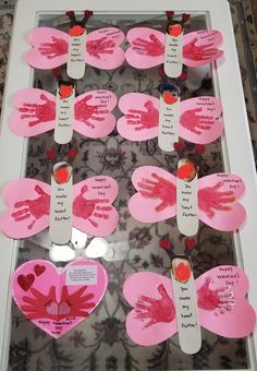 handprints and hearts are displayed in a shadow box