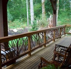 a wooden porch with rocking chairs on it and trees in the backgrouds