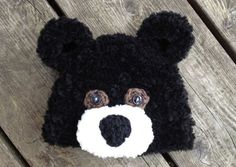 a black and white teddy bear hat sitting on top of a wooden bench