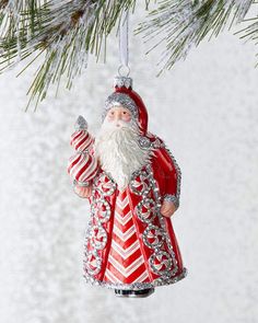 a santa clause ornament hanging from a christmas tree