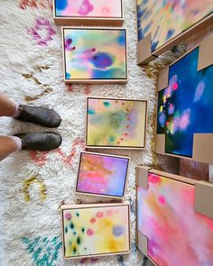 someone is painting on the floor with different colors and shapes in their paintings, including watercolors