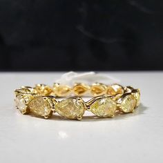 a yellow and white diamond ring sitting on top of a table