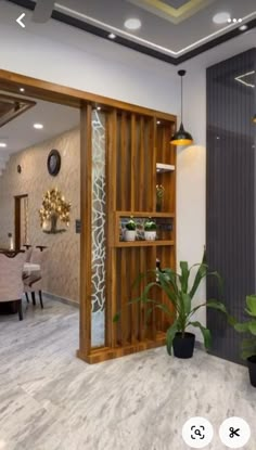 the interior of a modern home with wood accents and white marble flooring, along with potted plants