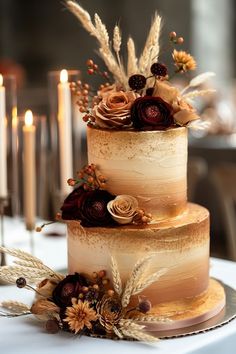 a three tiered cake sitting on top of a table next to candles and flowers