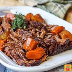 a close up of a plate of food with meat and carrots on it's side