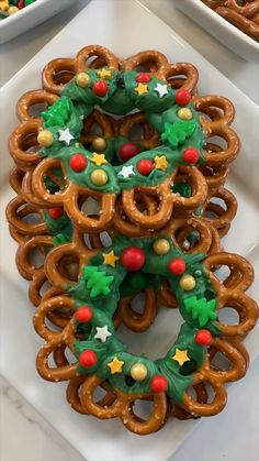 pretzels decorated with christmas decorations on a white platter next to other holiday treats