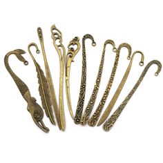 an assortment of antique brass hair clips and clippers, all with decorative designs on them