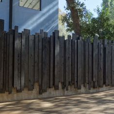 a skateboarder is doing a trick on the sidewalk near a fence and tree