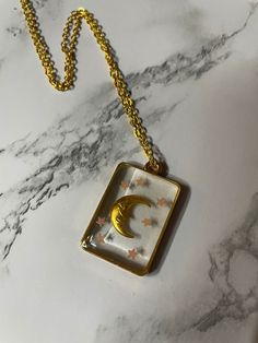 Cute little stars and peaceful moon pendant necklace. These pieces bring me so much joy to create and I hope they brighten up your day as well. Please use a soft cloth/lens wipe to clean off. Resin is pretty resistant but not 100% and can be scratched, please be careful when wearing/storing.  Please keep resin pieces out of direct sunlight and extreme heat. Connect with me on Instagram! @BananaWerks Feel free to message me with any questions! Moon Phase Star Charm Necklaces As Gift, Trendy Moon Charm Necklace As Gift, Handmade Celestial Charm Necklaces As Gifts, Trendy Moon-shaped Necklace For Gift, Trendy Moon Shaped Necklace For Gift, Trendy Moon Shaped Necklaces For Gifts, Handmade Star Charm Necklace For Gift, Handmade Star Charm Necklace As Gift, Handmade Crescent Charm Necklaces As Gift