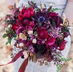 a bridal bouquet with purple and red flowers