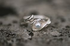 "A beautiful  pearl promise ring called \"water\", because its soft curves reminds an ocean wave and being open at the front makes it a perfect gift if you are not sure about the size of  the finger.   A great 12th anniversary gift as pearl is the stone for this special occasion.  The high quality  5 mm (o.2 inches)  freshwater pearl is carefully put  into the ring design, and it is firmly connected to the ring with a pin.  I designed the ring first in wax and then cast  it  in sterling silver. Pearl Promise Rings, Ring With Pearl, Cute Promise Rings, Pearl Anniversary, Ocean Ring, Silver Pearl Jewelry, Anniversary Rings For Her, Silver Pearl Ring, 12th Anniversary