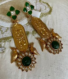 Introducing our Emerald Green Long Gold Carving Earrings with Bird Design. These stunning earrings feature intricate gold carvings and rich emerald green stones, beautifully accented by a delicate bird motif. Perfect for adding a touch of nature-inspired elegance to any ensemble. Ideal for both special occasions and everyday wear. Earrings Dimension: Approximately 3.6 inches Long Approximately 1.2 inches wide  A Earring weight is 0.5 0z All our products are crafted using traditional skills from our rich heritage. The manual nature of these crafts means that irregularities or variations are inherent in the handcrafting process. Ceremonial Green Earrings For Festivals, Traditional Heavy Green Earrings, Festive Temple Jewelry Emerald Earrings, Elegant Green Earrings With Intricate Design, Festive Emerald Temple Jewelry Earrings, Ornate Meenakari Danglers As Gift, Green Earrings For Anniversary And Festivals, Festive Emerald Temple Earrings, Green Meenakari Gold-plated Earrings