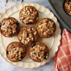 several muffins on a plate next to a baking pan