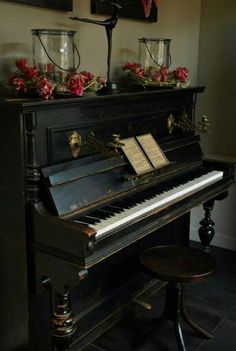 an old black piano with flowers on top