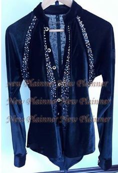 a black jacket with pearls and beads on the collar is hanging from a clothes rack