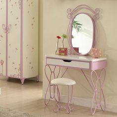 a pink dressing table with mirror and stool