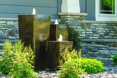 three water fountains in front of a house