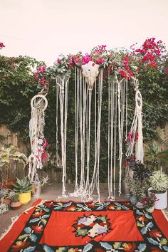 an area rug with flowers hanging from it and other decorations on the ground next to it