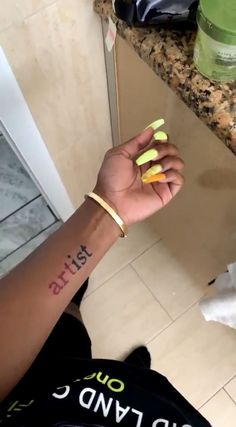 a person with yellow nail polish on their left hand and the word just married written on her right wrist